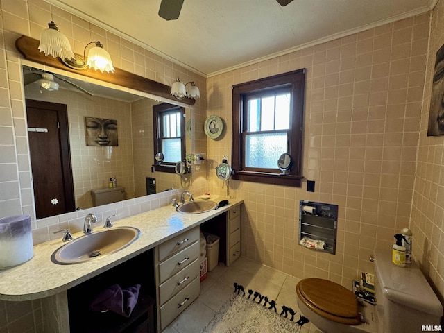 bathroom with tile patterned flooring, vanity, tile walls, toilet, and ornamental molding