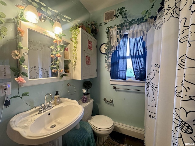 bathroom with sink, curtained shower, and toilet