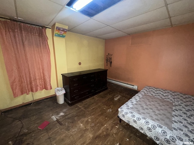 unfurnished bedroom with a baseboard radiator and a drop ceiling