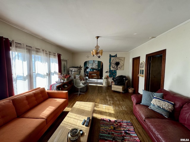 living room featuring dark wood-type flooring, ornamental molding, and a notable chandelier