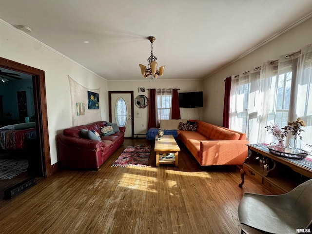 living room featuring a healthy amount of sunlight, wood-type flooring, and a notable chandelier