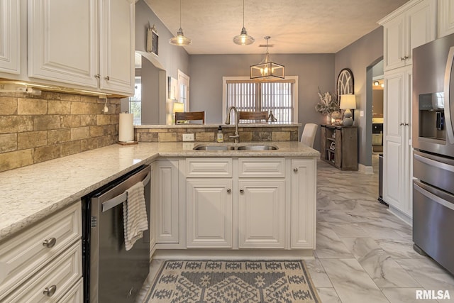 kitchen with kitchen peninsula, appliances with stainless steel finishes, backsplash, hanging light fixtures, and sink