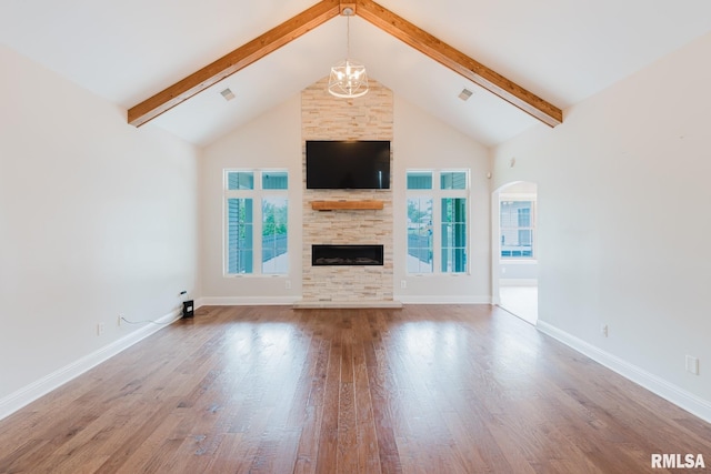 2730 Kokopelli Dr, Marion, IL 62959 - unfurnished living room with arched walkways, beamed ceiling, healthy amount of natural light, high vaulted ceiling, and wood finished floors
