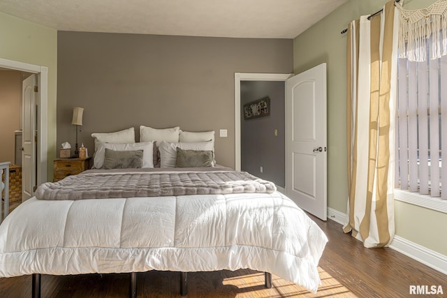 bedroom featuring dark wood-style flooring and baseboards