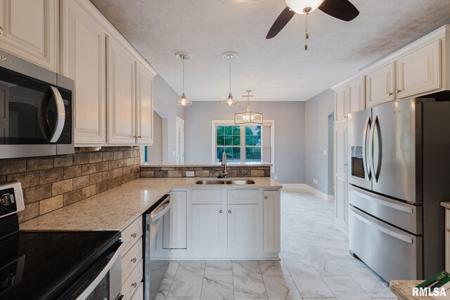 2730 Kokopelli Dr, Marion, IL 62959 - kitchen featuring stainless steel appliances, a sink, ceiling fan, decorative backsplash, and a peninsula
