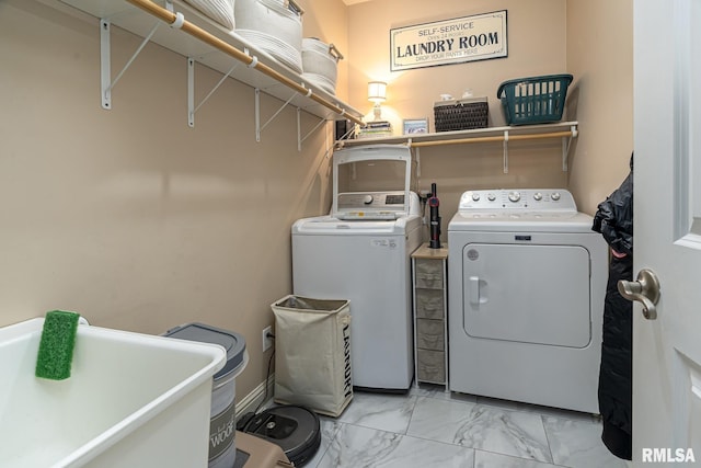 laundry area featuring laundry area, marble finish floor, a sink, and washer and clothes dryer