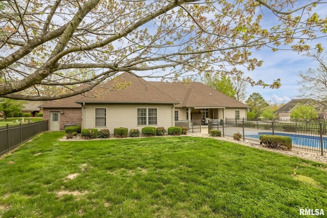 view of front of property with a fenced backyard, roof with shingles, a patio area, a front yard, and a fenced in pool