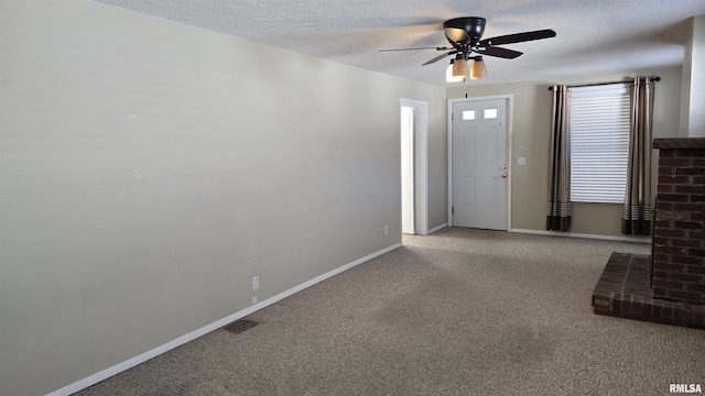 carpeted entrance foyer featuring ceiling fan and a textured ceiling