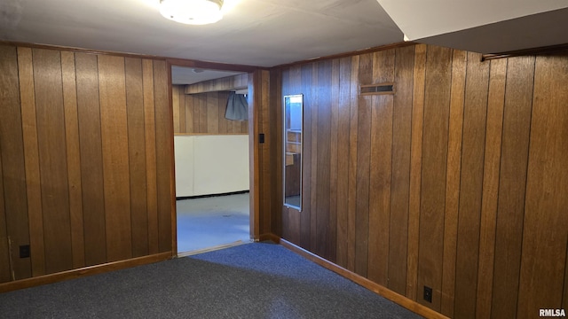 corridor featuring wood walls and carpet flooring