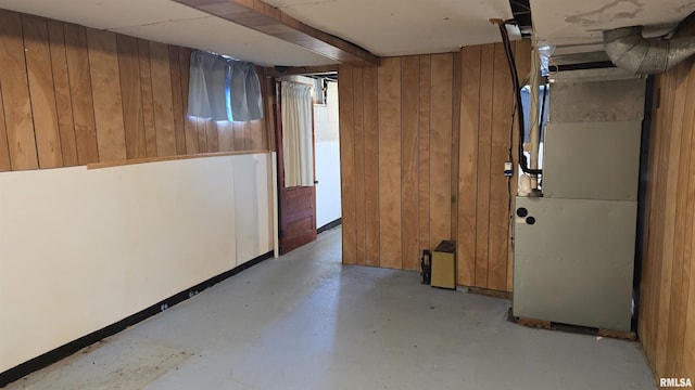 basement with heating unit and wooden walls