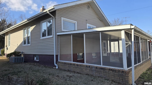 view of side of home with central AC and a sunroom