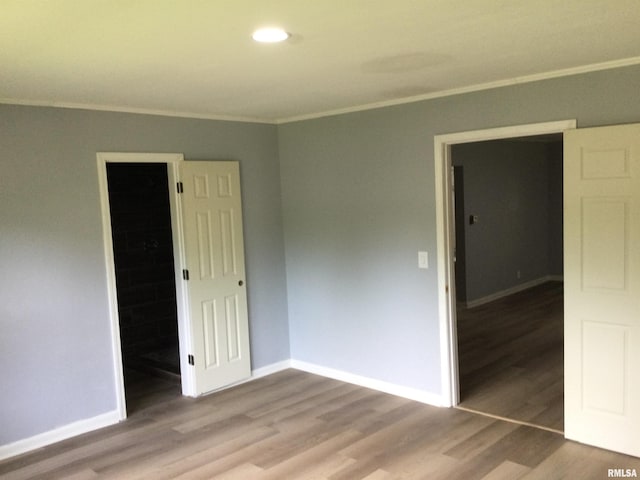 unfurnished room with crown molding and wood-type flooring