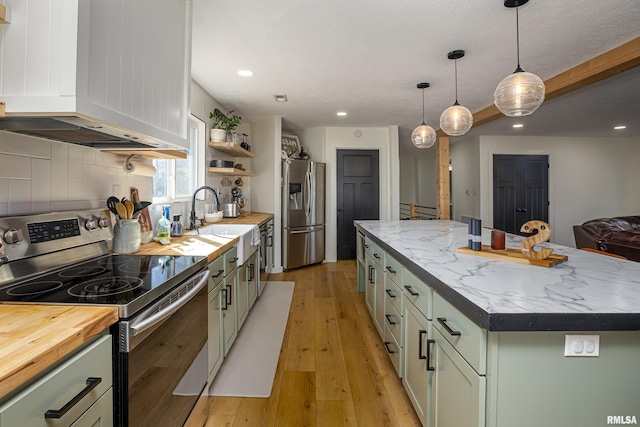 kitchen with a center island, green cabinetry, sink, backsplash, and stainless steel appliances