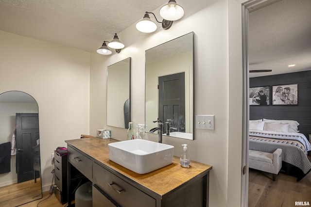 bathroom featuring hardwood / wood-style floors, vanity, and a textured ceiling