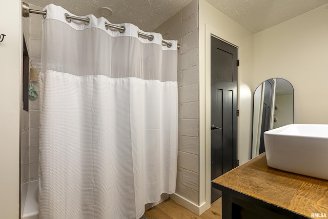 bathroom featuring sink, a shower with curtain, a textured ceiling, and wood-type flooring