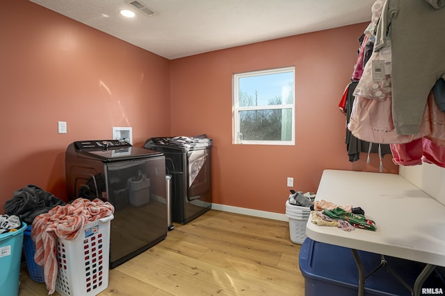 washroom with light hardwood / wood-style floors and washer and clothes dryer