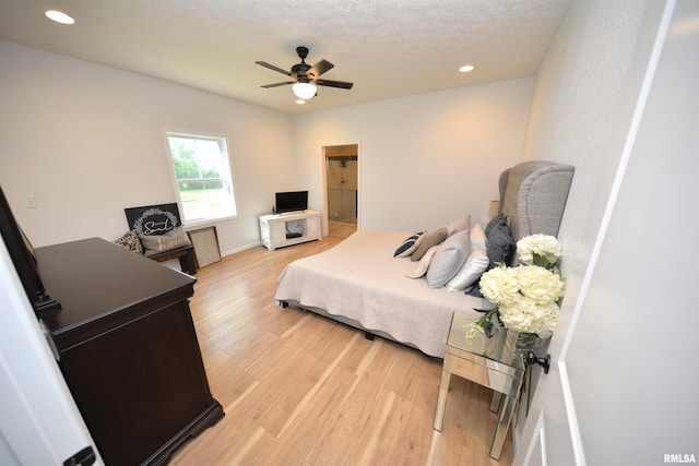 bedroom featuring wood-type flooring, a textured ceiling, and ceiling fan