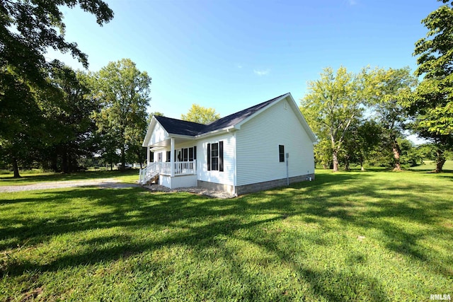 view of side of property featuring covered porch and a yard