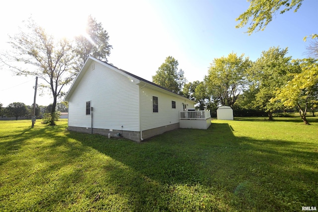 view of side of home with a storage shed and a yard