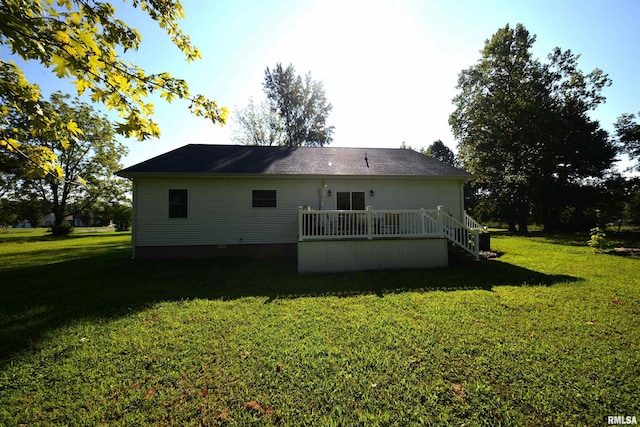 rear view of house featuring a yard and a deck