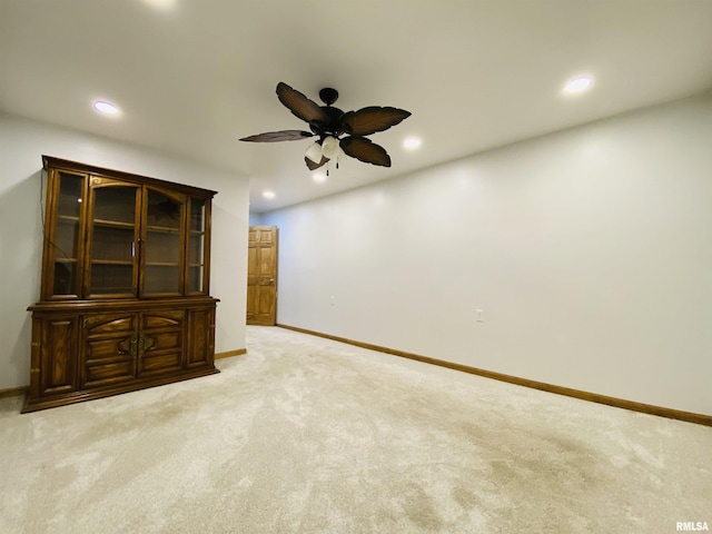 empty room featuring ceiling fan and light colored carpet