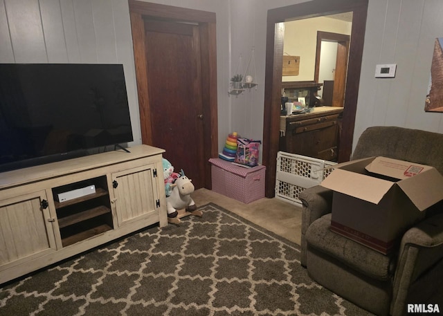 carpeted living room featuring wooden walls