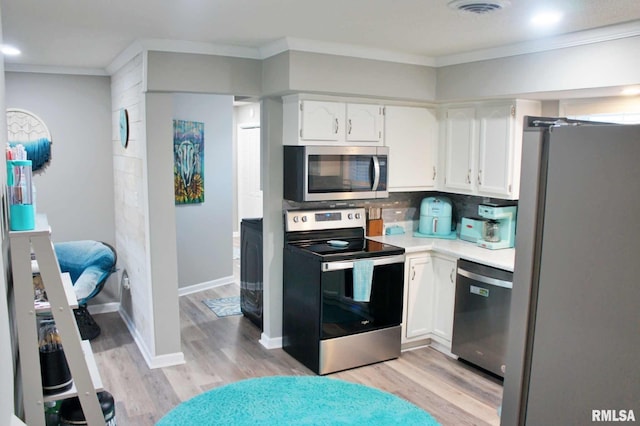 kitchen with white cabinets, crown molding, appliances with stainless steel finishes, and decorative backsplash