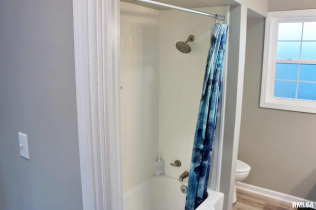 bathroom featuring toilet, shower / tub combo, plenty of natural light, and hardwood / wood-style flooring