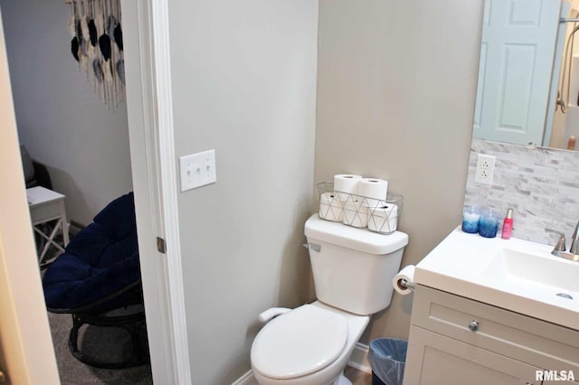 bathroom featuring vanity, backsplash, and toilet