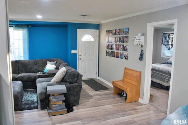 living room with ornamental molding and light hardwood / wood-style floors