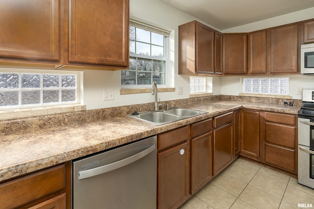 kitchen with sink, light tile patterned flooring, and stainless steel appliances