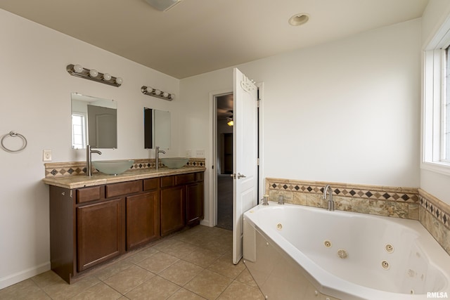 bathroom featuring a relaxing tiled tub, tile patterned floors, and vanity