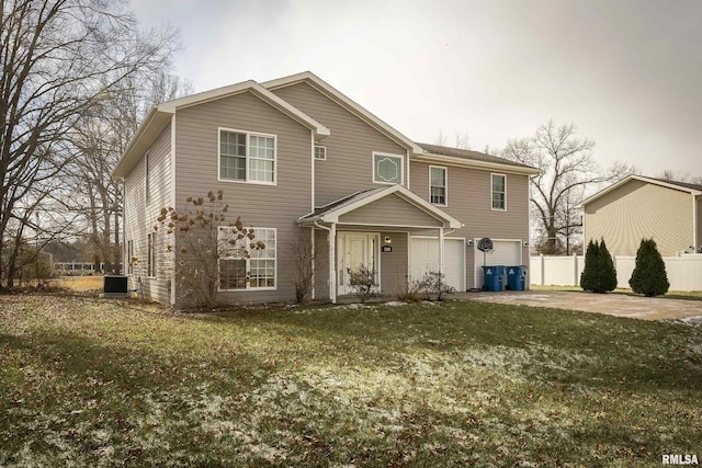 front of property with a garage, central air condition unit, and a front yard