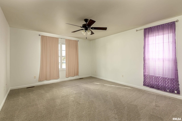 carpeted spare room with ceiling fan