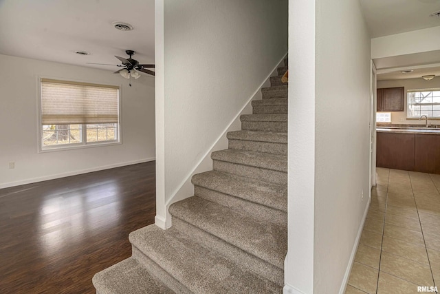 staircase with sink, ceiling fan, and tile patterned floors