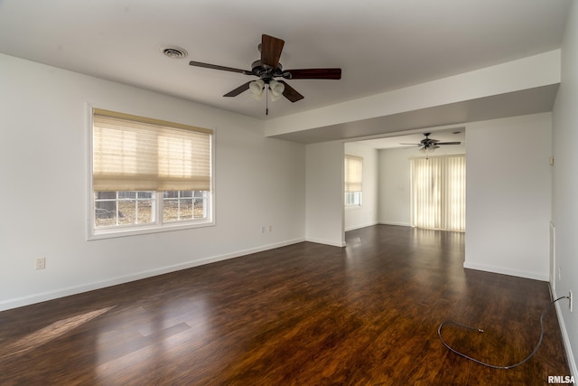 empty room with ceiling fan and dark wood-type flooring