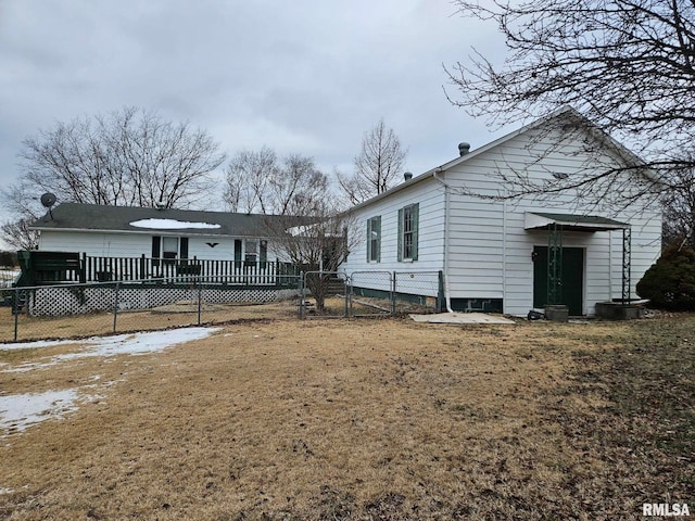 rear view of house featuring a deck and a yard