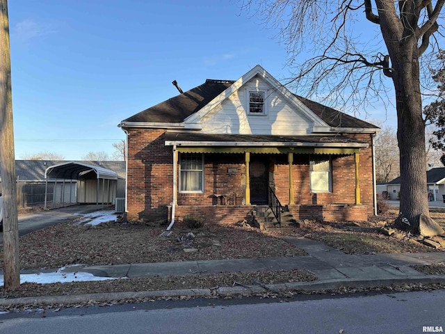 bungalow-style house with a carport, central AC unit, and covered porch