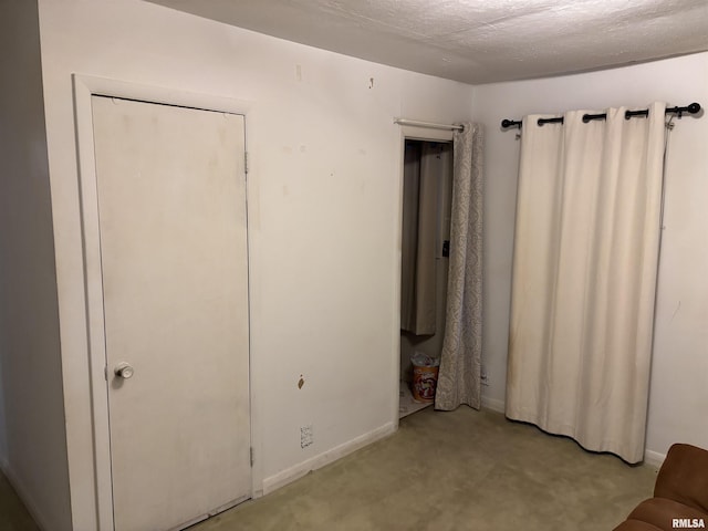 unfurnished bedroom with light colored carpet and a textured ceiling