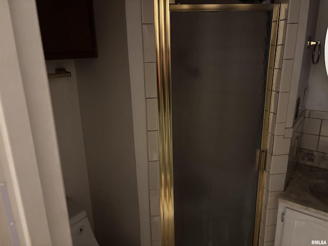 bathroom with tasteful backsplash, vanity, toilet, and a shower with shower door