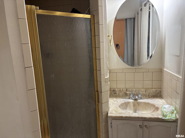 bathroom featuring tasteful backsplash, an enclosed shower, and vanity