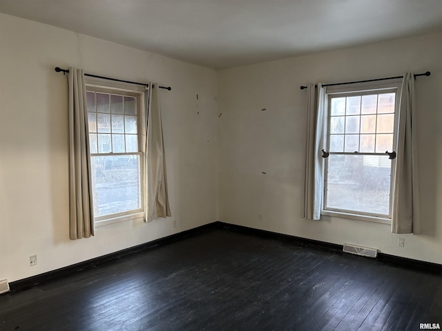 empty room with dark hardwood / wood-style flooring