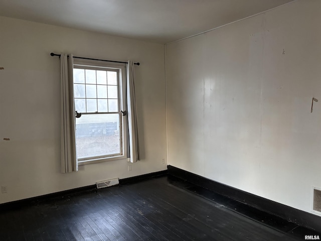 empty room featuring a healthy amount of sunlight and dark wood-type flooring