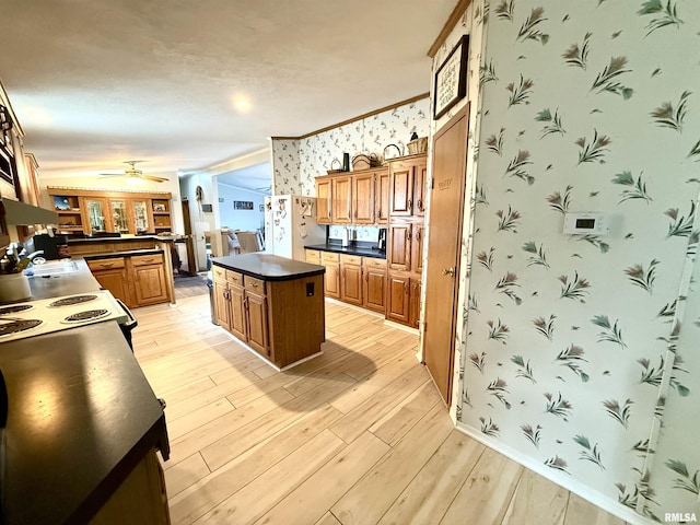 kitchen with a center island, ornamental molding, refrigerator with ice dispenser, ceiling fan, and light hardwood / wood-style floors