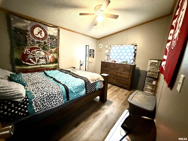 bedroom featuring lofted ceiling, ornamental molding, light hardwood / wood-style floors, and ceiling fan