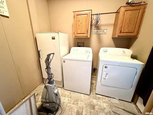 clothes washing area with cabinets and separate washer and dryer