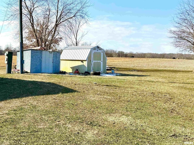 view of yard with a rural view and a storage shed