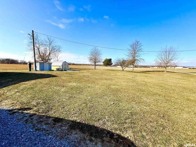 view of yard with a rural view and a storage unit