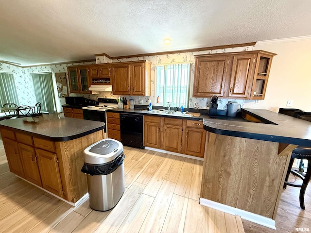 kitchen featuring a kitchen bar, a textured ceiling, light wood-type flooring, dishwasher, and range with electric cooktop