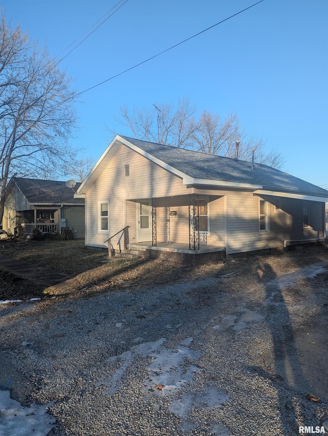 view of side of property featuring covered porch